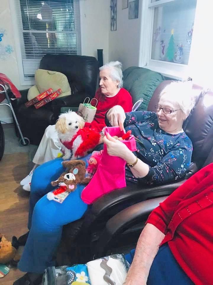 Two people on recliners holding stuffed dolls in a bright living room