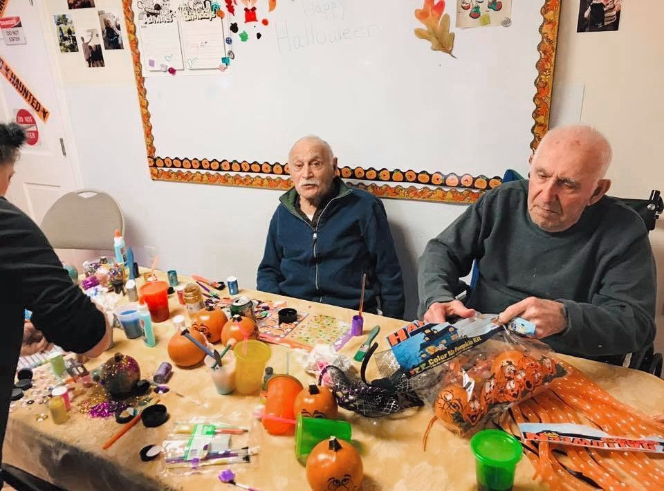 People seated at a decorated table with food and drinks at a festive indoor gathering.