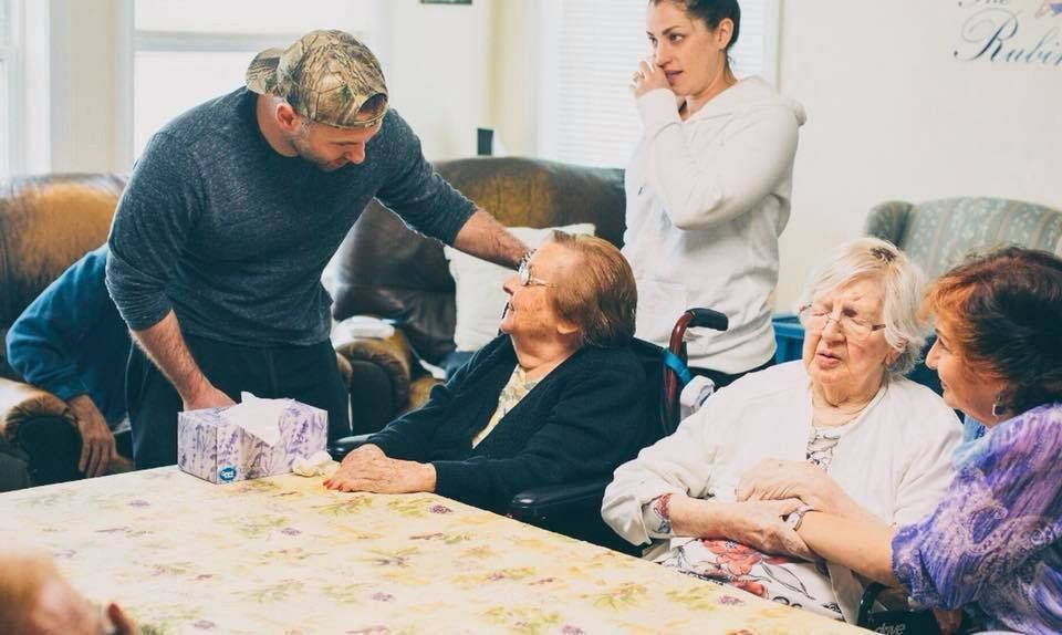 People gathered around a table, smiling and chatting during a casual indoor celebration