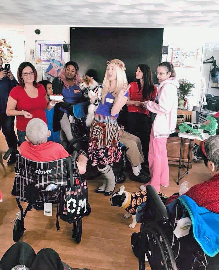 Teacher and students gathered in a classroom, with one person speaking at the front.