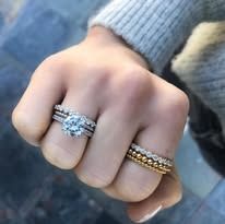 Hand wearing multiple diamond rings.