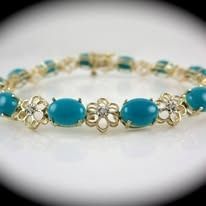 Gold bracelet with turquoise stones and flower accents.