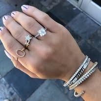 Hand wearing multiple rings and bracelets.