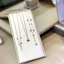 Necklaces displayed on a white, rectangular jewelry holder.
