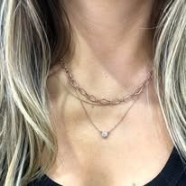Woman wearing two layered gold necklaces.