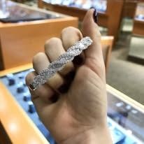 Hand holding a sparkly diamond ring in a jewelry store.