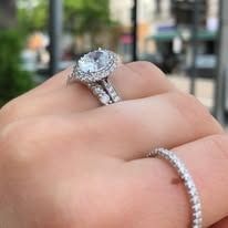 Hand with engagement ring and diamond band.