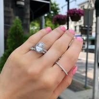Hand wearing two diamond rings.