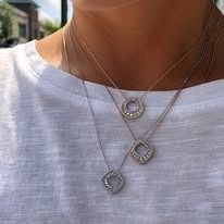 Woman wearing three delicate diamond necklaces.