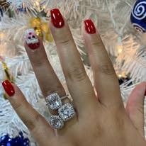 Hand with red nails and large diamond ring.