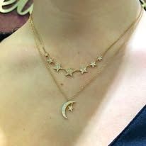 Gold layered necklace with star and moon pendants.