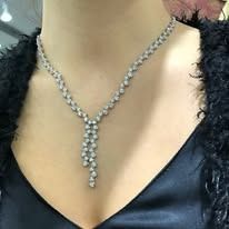 Woman wearing a diamond necklace with a black top.