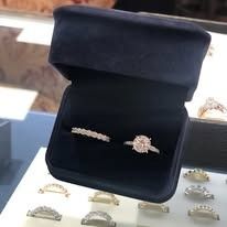 Blue velvet ring box with two diamond rings inside.