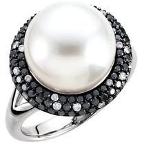 Pearl ring with black and white gemstones in a silver setting.