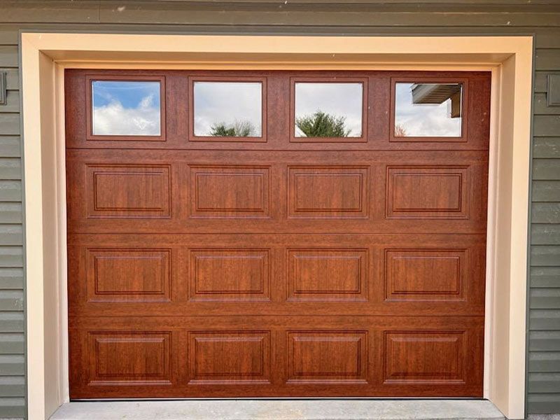 A wooden garage door with a window in it