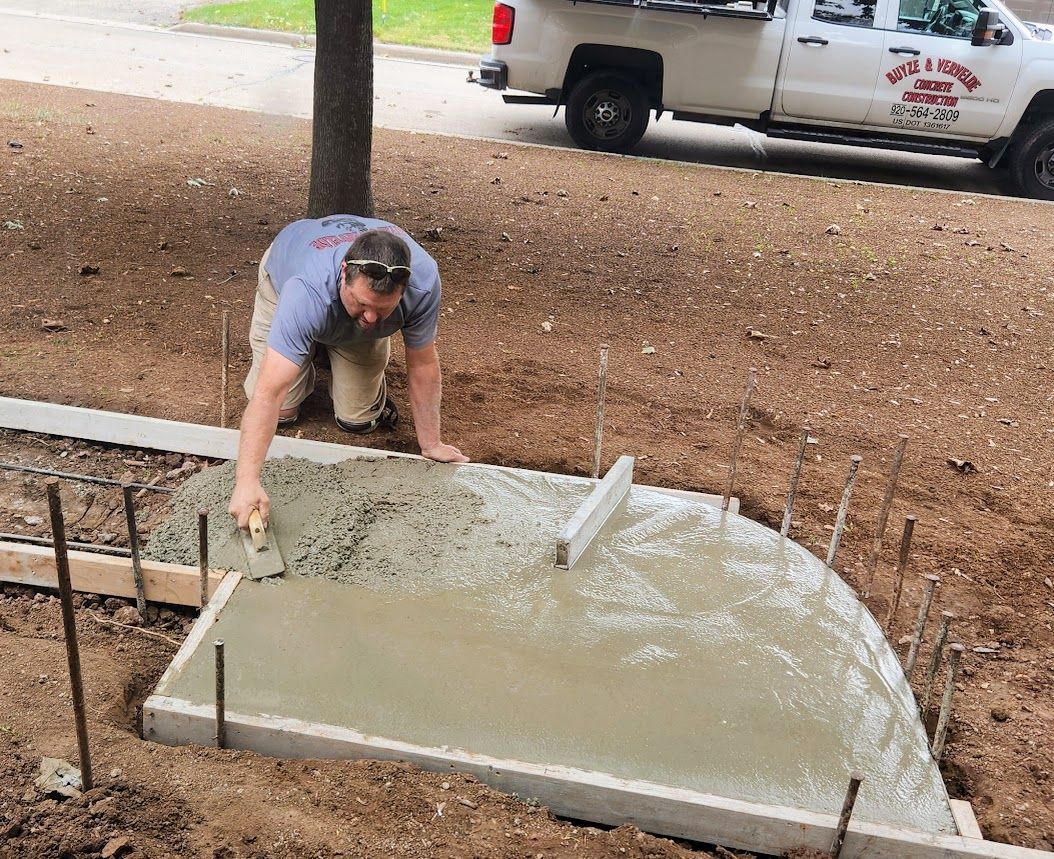 A man is kneeling on a concrete surface.