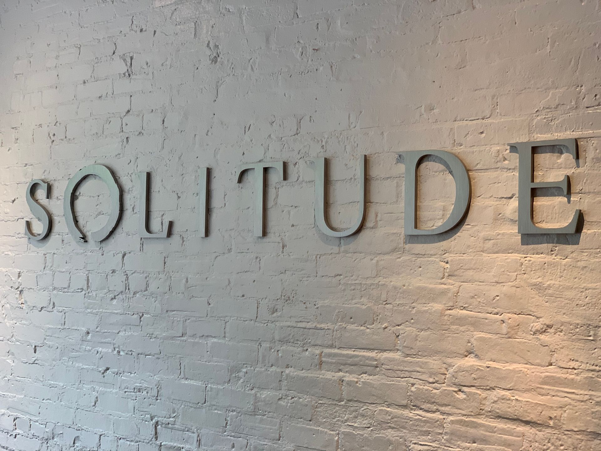 solitude interior 3d lettering on white brick wall
