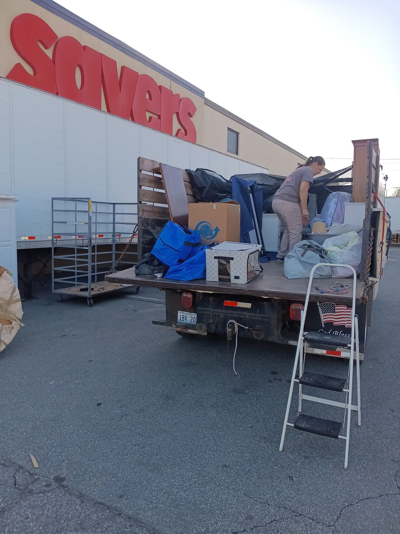 A sony 's truck is loaded with furniture and a ladder