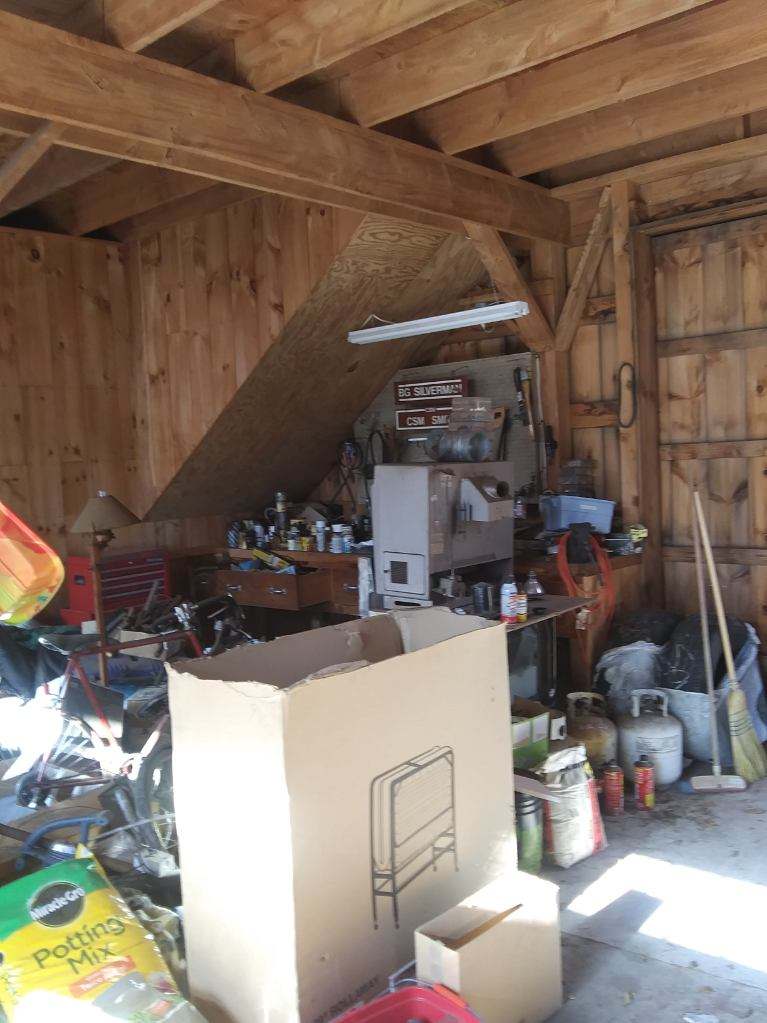 A garage filled with lots of junk and boxes.