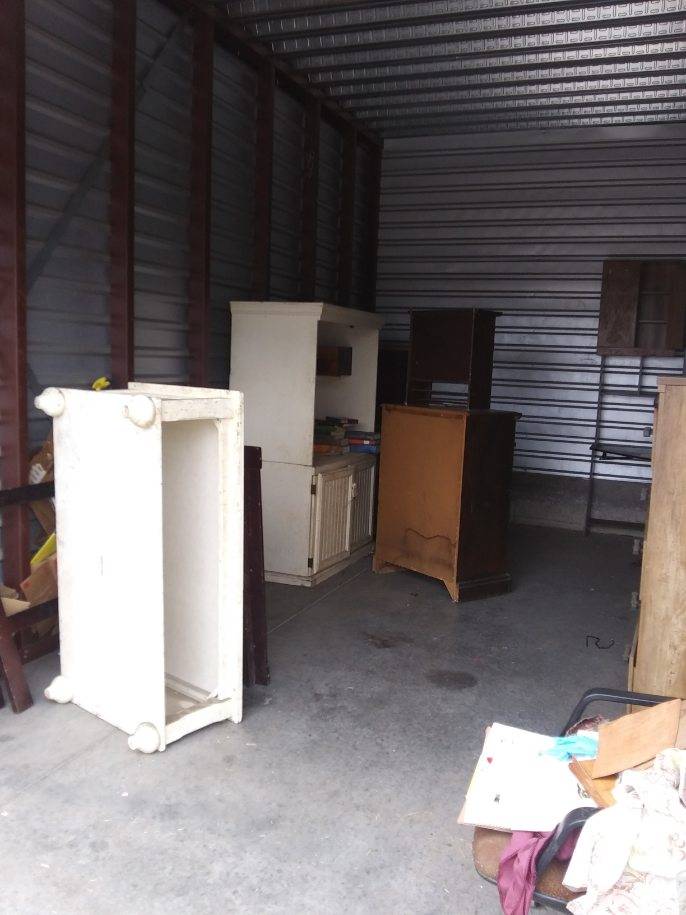 A warehouse filled with lots of furniture including a dresser