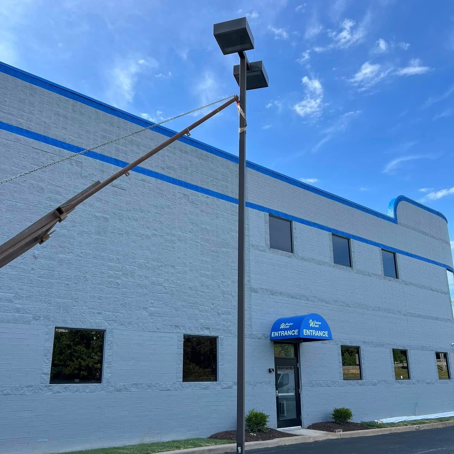 A large white building with a blue awning and a street light