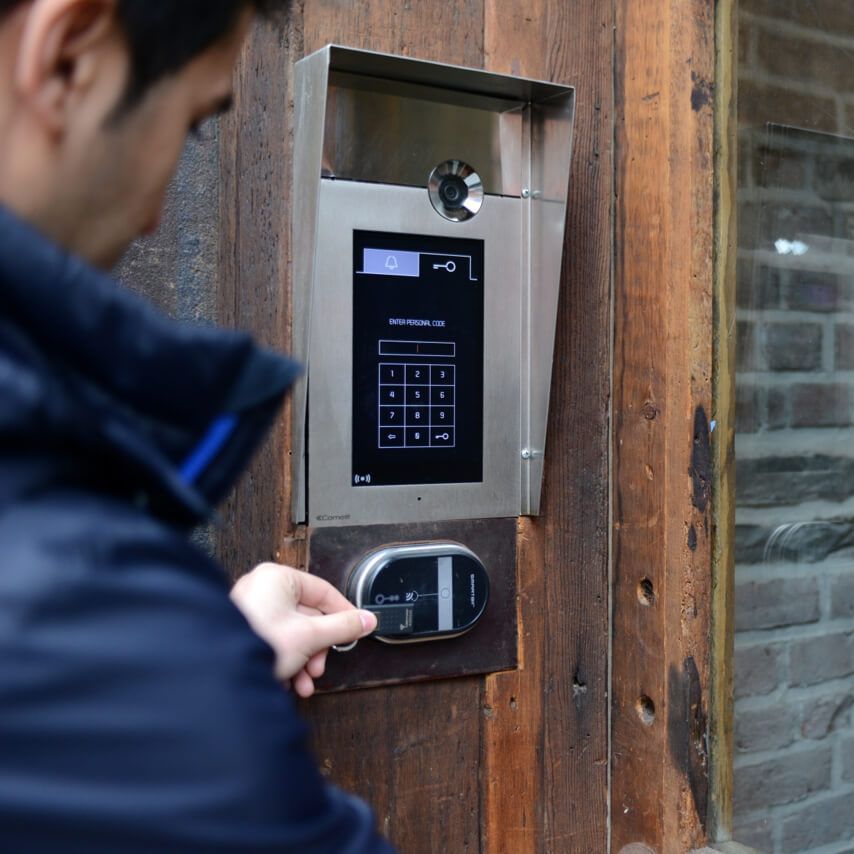 A man is using a keypad on a wooden door