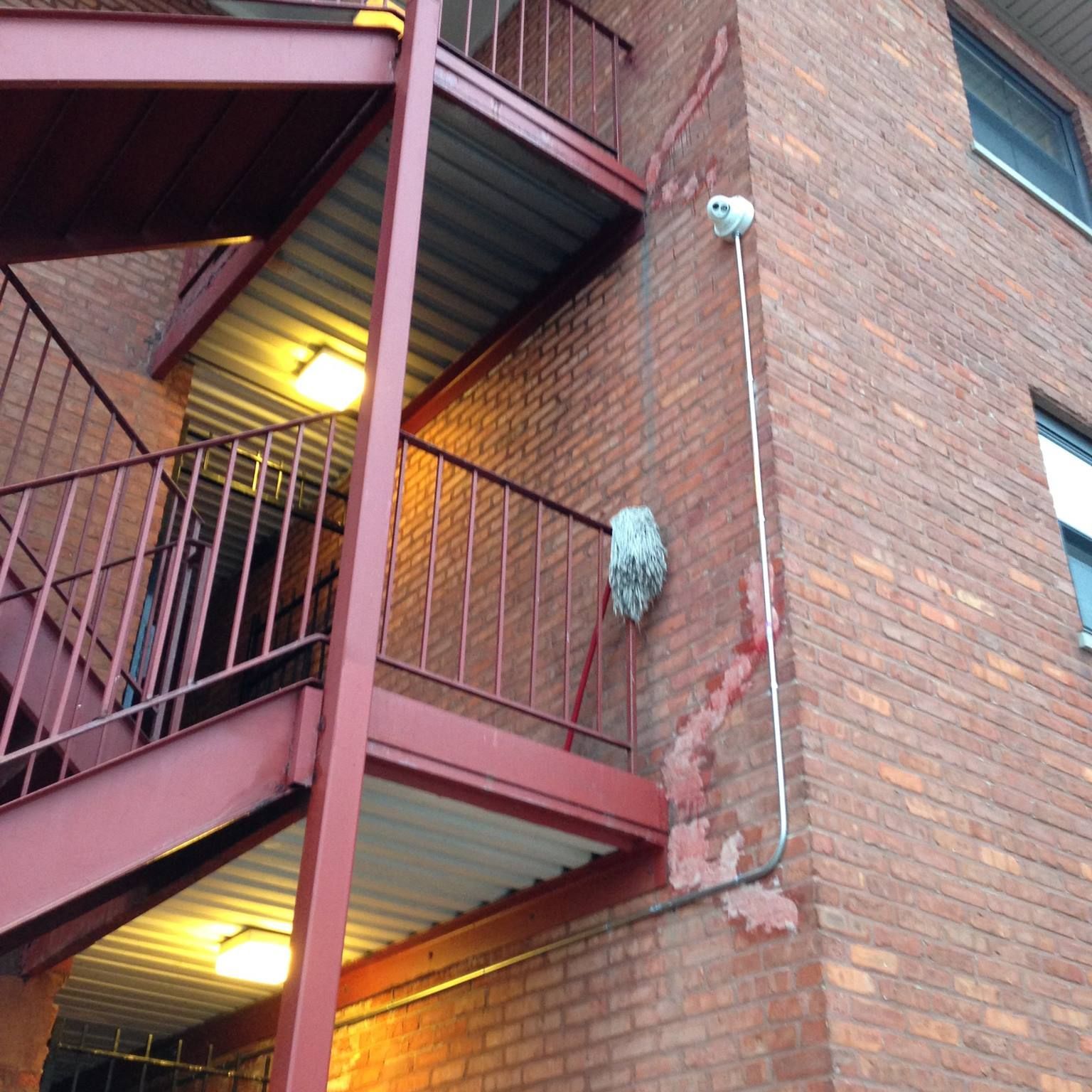 A red fire escape on the side of a brick building