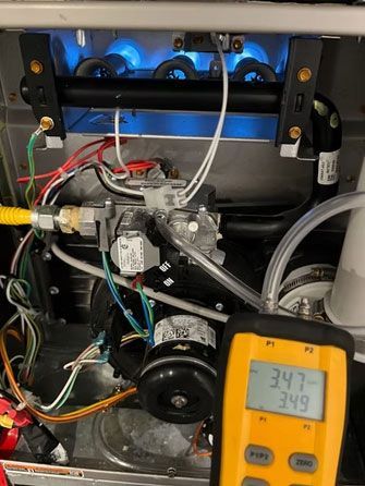 Close-up of machine internals with wires, tubing, and a digital meter reading 34.7 and 34.9