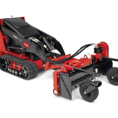 Red Toro mini skid steer with attached trencher.
