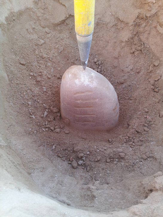 A shovel is digging a hole in the dirt.