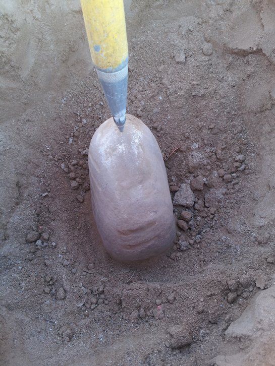 A shovel is digging a hole in the dirt.