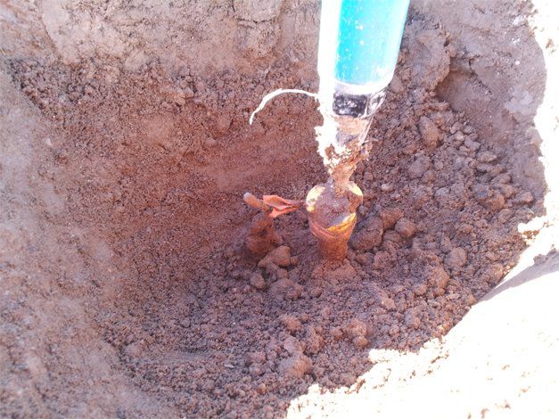 A person is using a drill to dig a hole in the ground