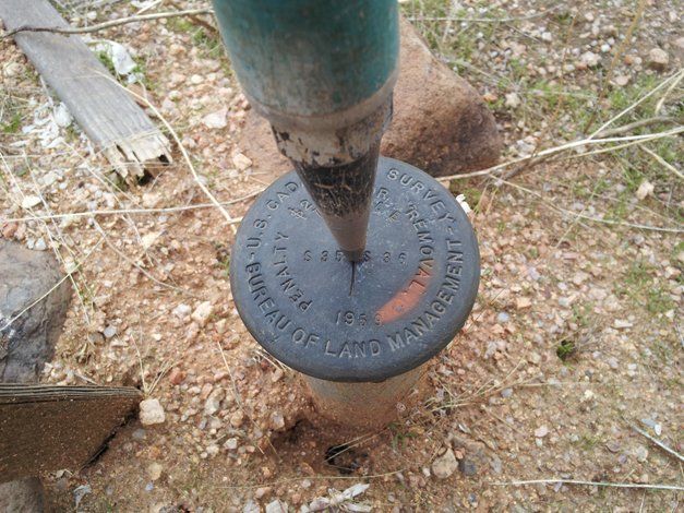 A pencil is sticking out of a hole in the ground.