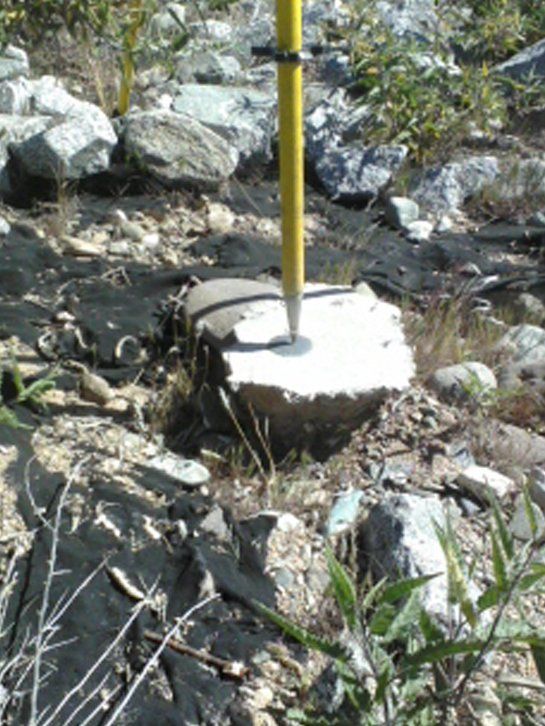 A yellow pole is sitting on top of a rock