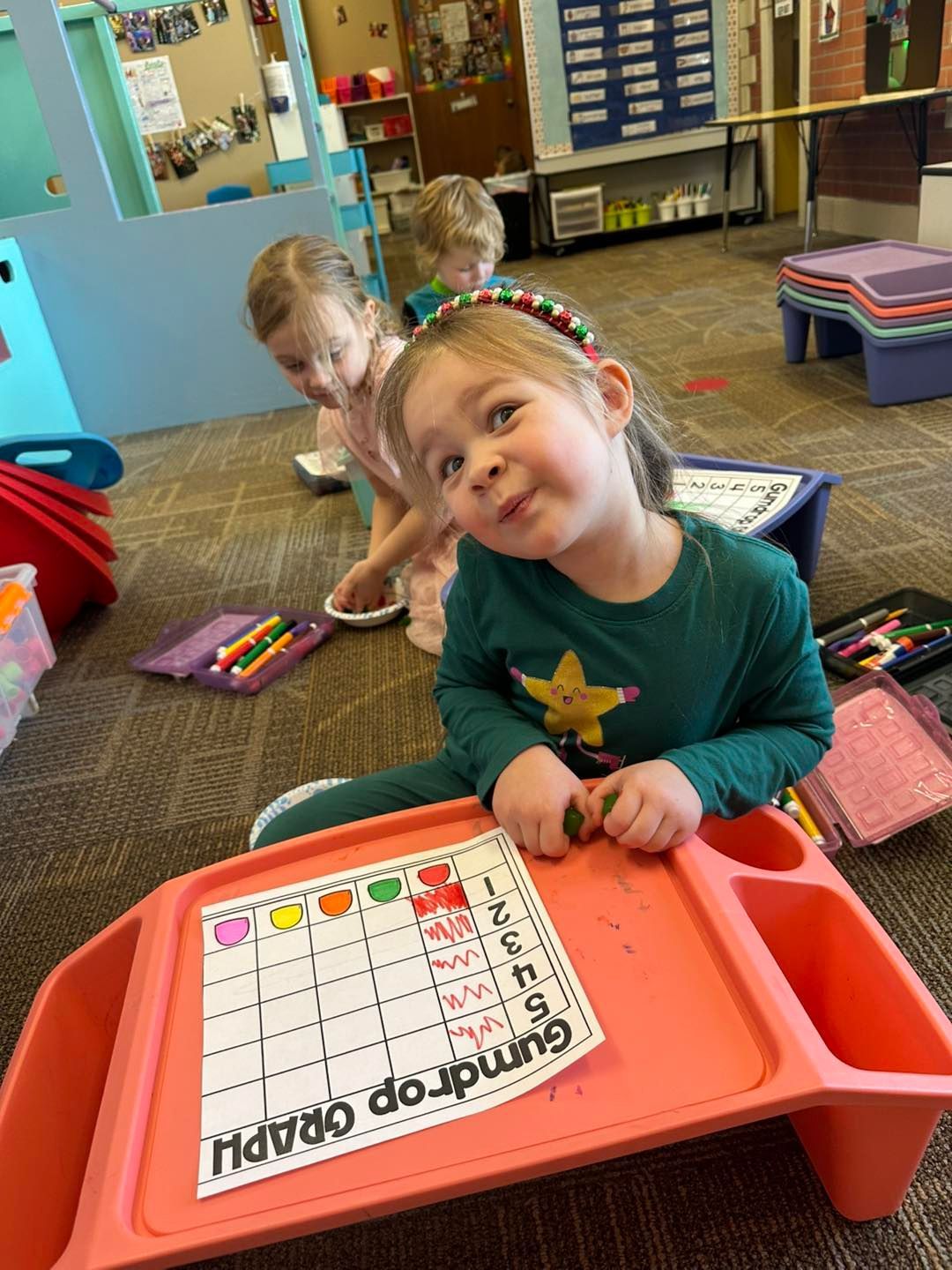 A little girl is sitting at a table with a graph on it.