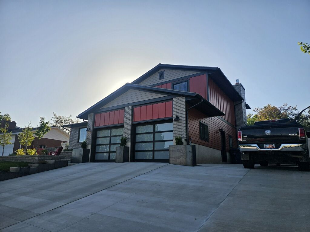 Garage with red accents and glass doors; a black truck is parked in the driveway.
