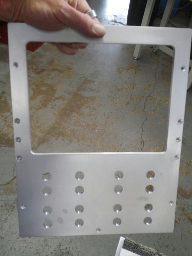 a person is holding a piece of metal with holes in it