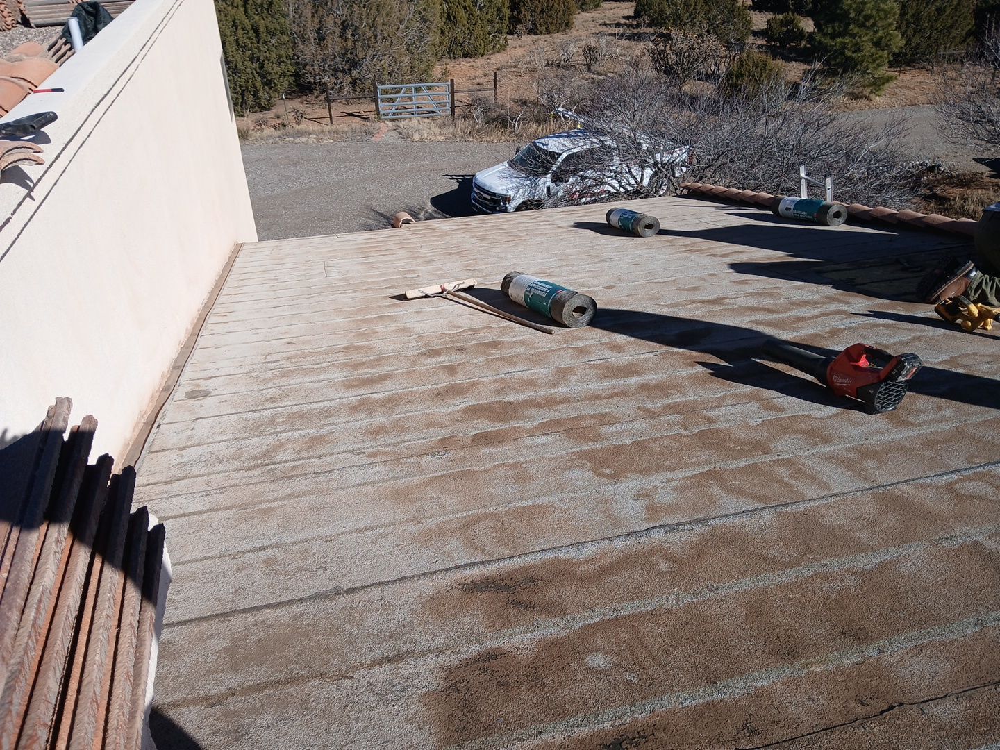 Rooftop with debris, cans, and an abandoned vehicle in a desert-like setting.