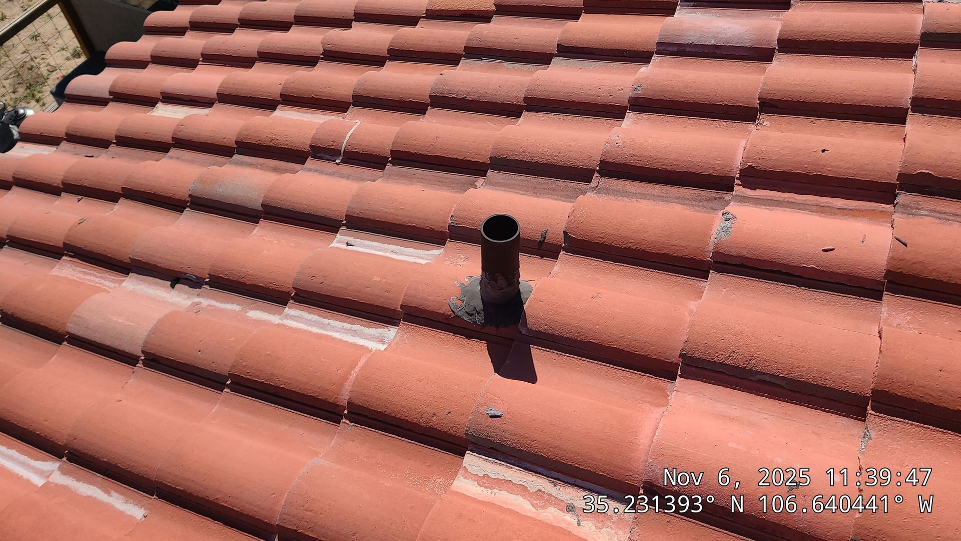 Red tile roof with a black pipe vent.