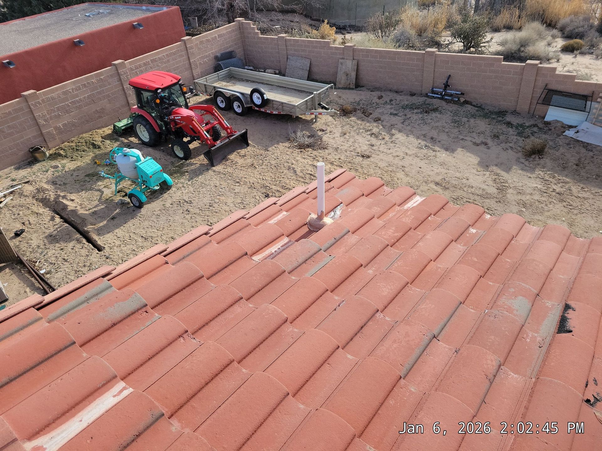 Red-roofed house with construction equipment in the backyard