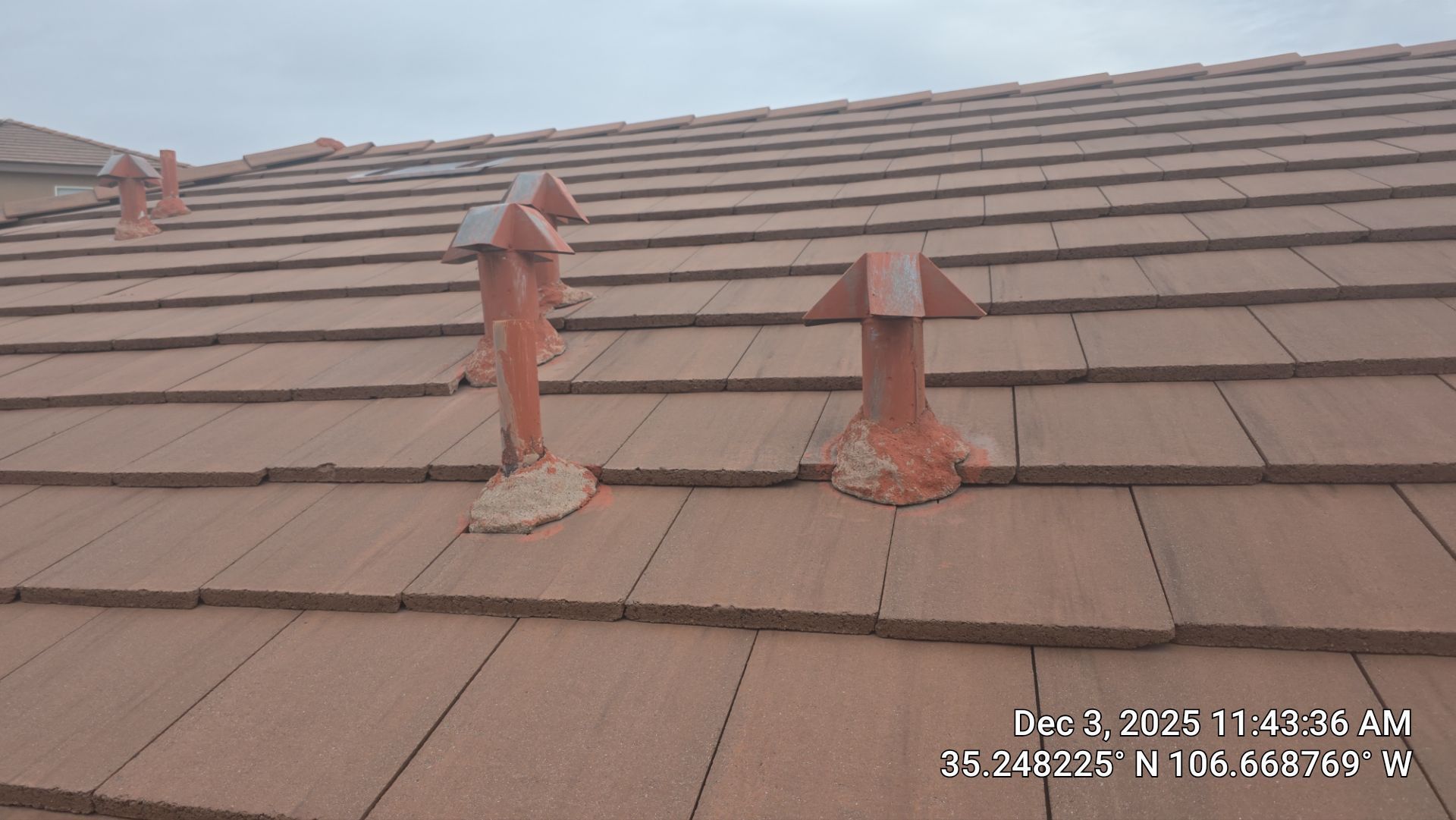 Brown tile roof with several clay ventilation units.