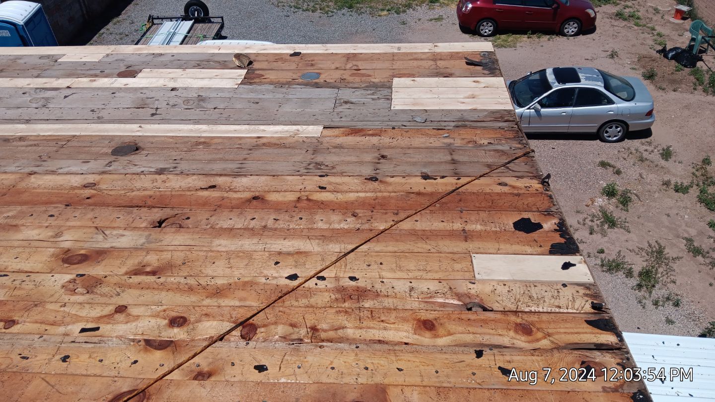 Wooden rooftop with a car parked nearby.