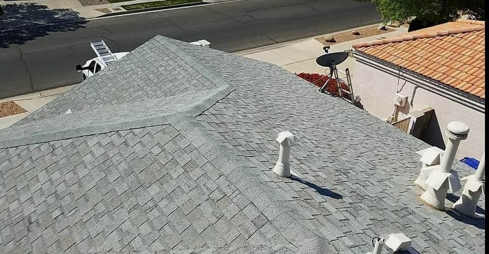 Gray shingled roof with multiple vents and a satellite dish, viewed from above.