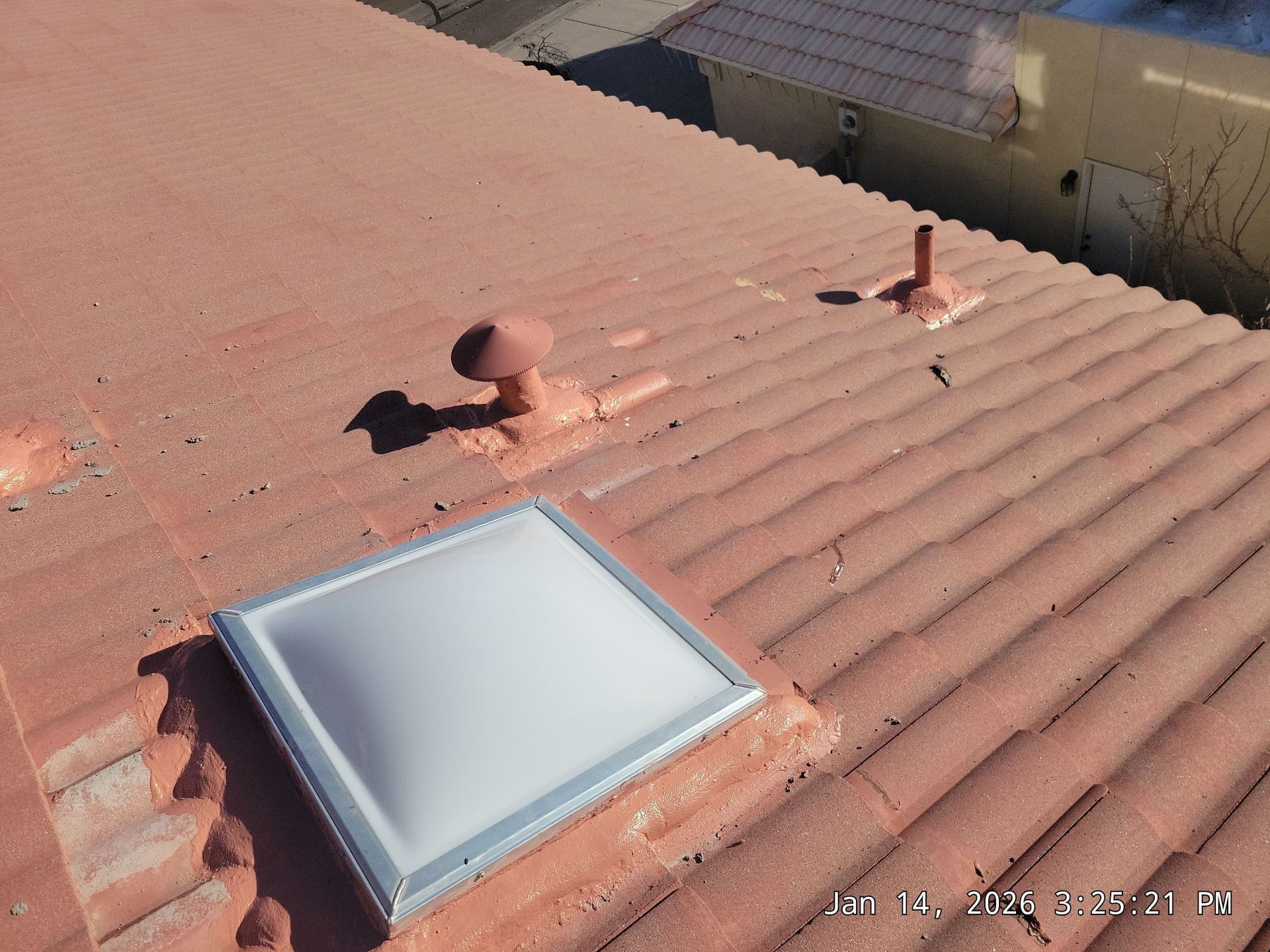 Red tile roof with a skylight and vents.