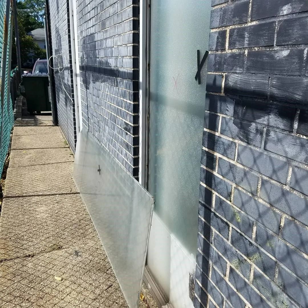 A brick wall with a chain link fence behind it