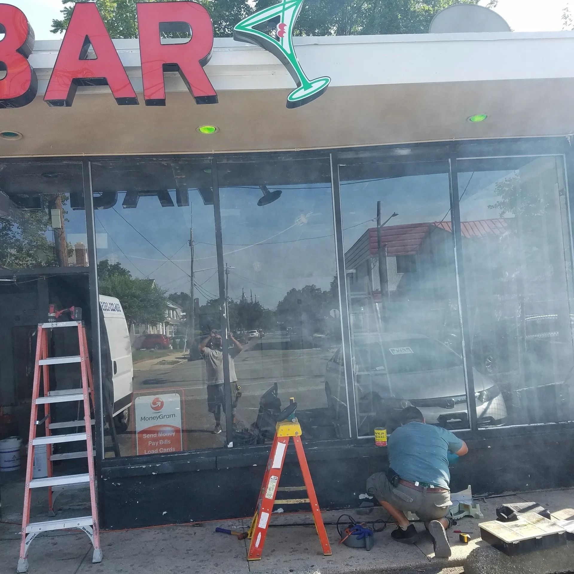 A man is working on the outside of a bar