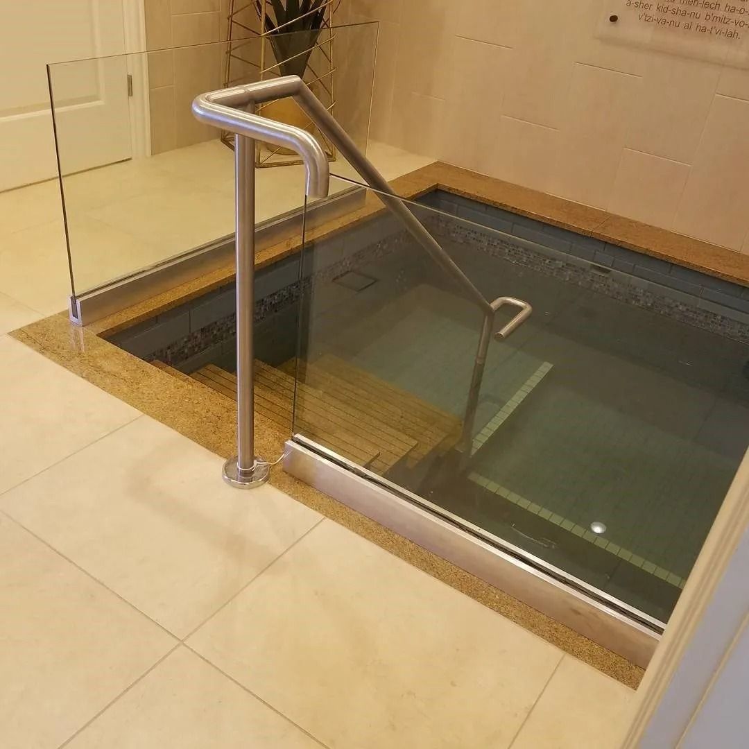 A bathtub with stairs leading up to it and a glass railing
