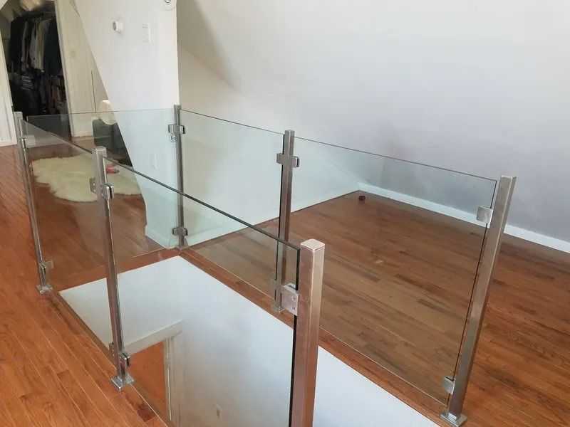 A staircase with a glass railing and a wooden floor.