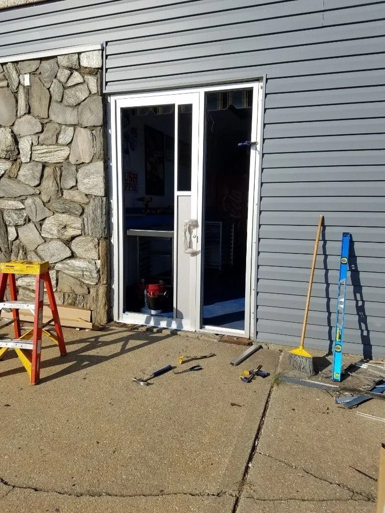A sliding glass door is being installed on the side of a building.