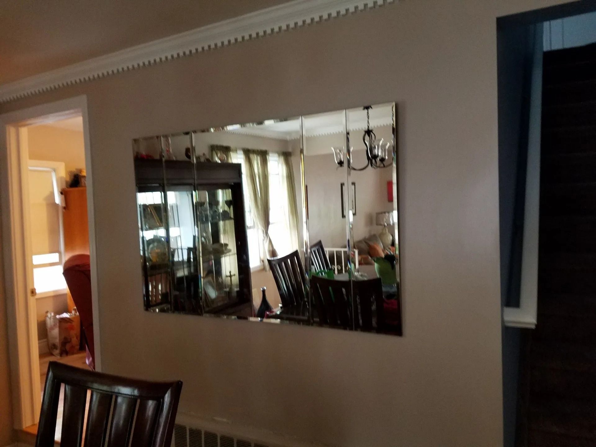 A dining room with a large mirror on the wall